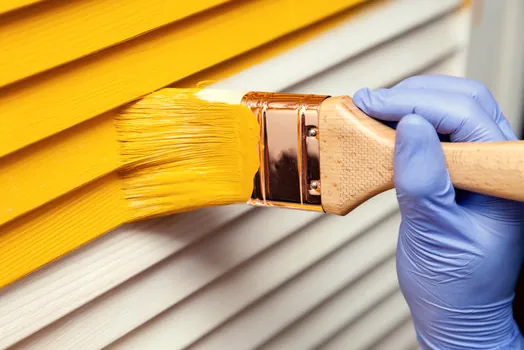 Brushing a rich color onto louvered shutters at a Lake Sherwood home
